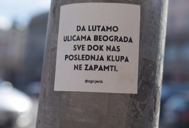 a sticker on a pole on a city street