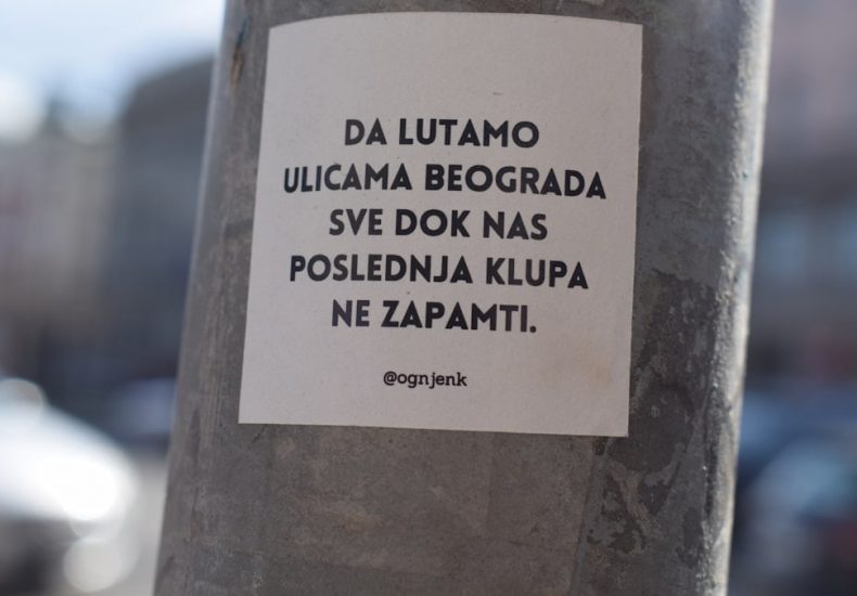 a sticker on a pole on a city street